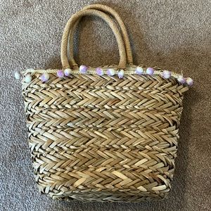 Straw basket with purple and white pompoms